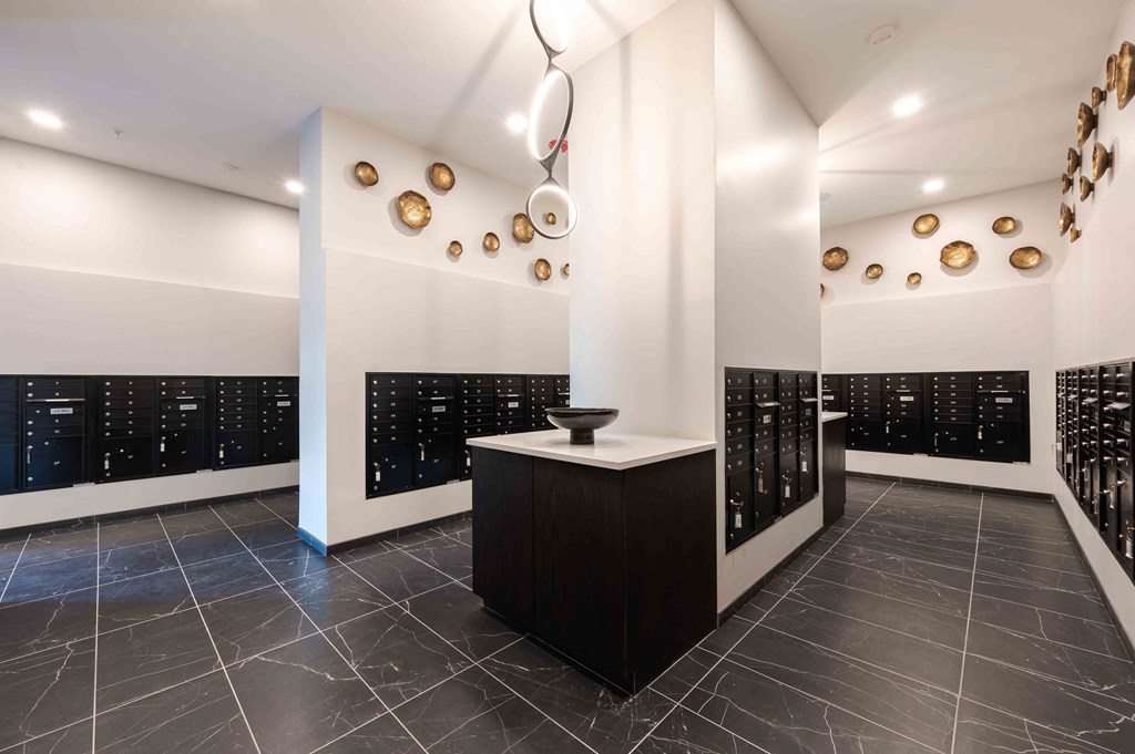 A black and white hallway with a white pillar and a black counter.