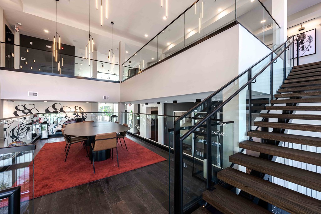 A modern house interior with a staircase, dining table and chairs.