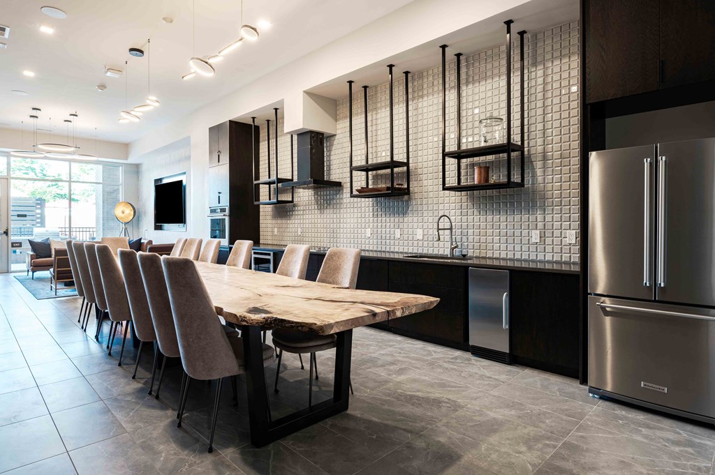 A modern kitchen with a long table and chairs.