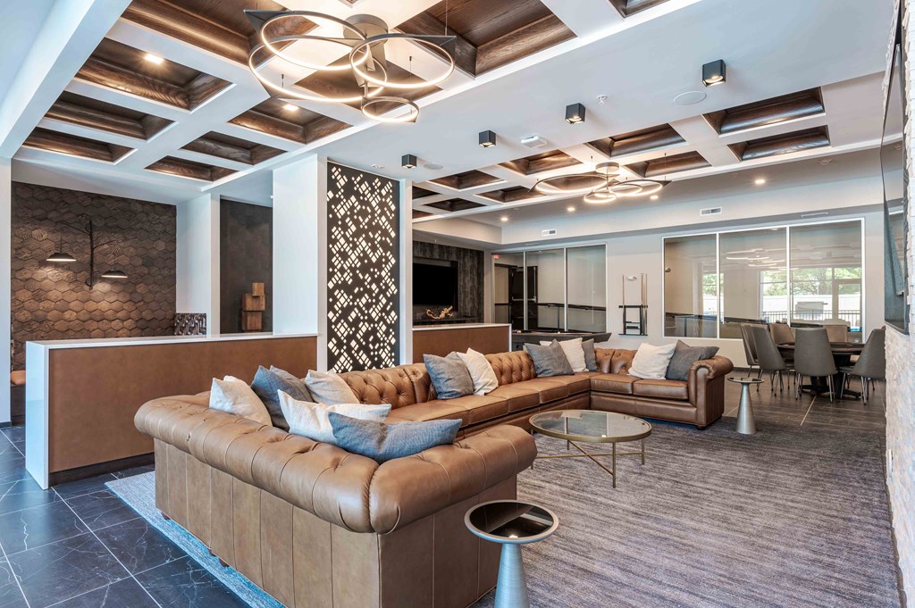 A modern living room with a brown sofa and a glass table.