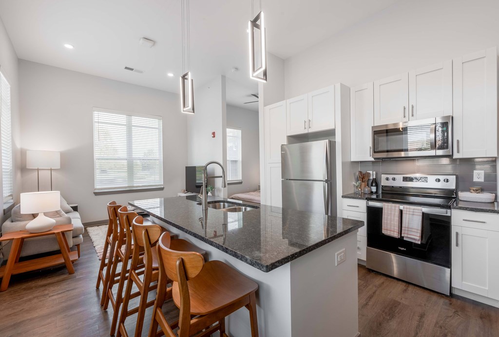 A modern kitchen with a large island and stainless steel appliances.