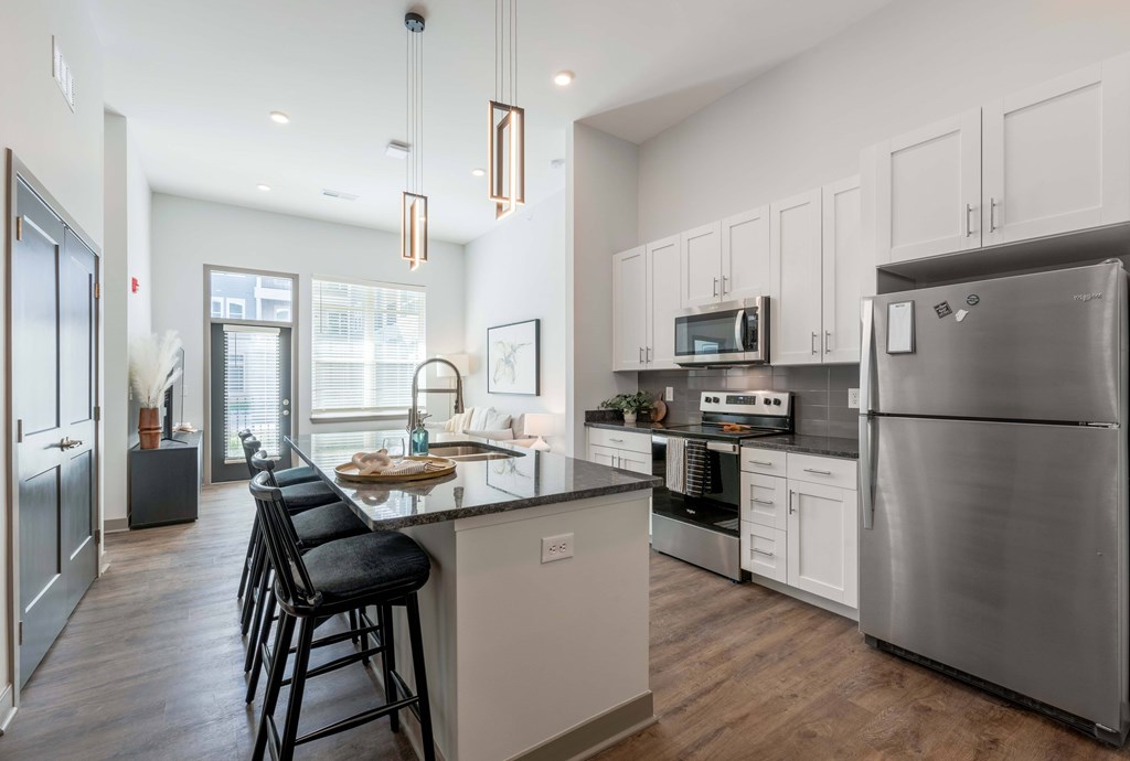 A modern kitchen with a large island and stainless steel appliances.