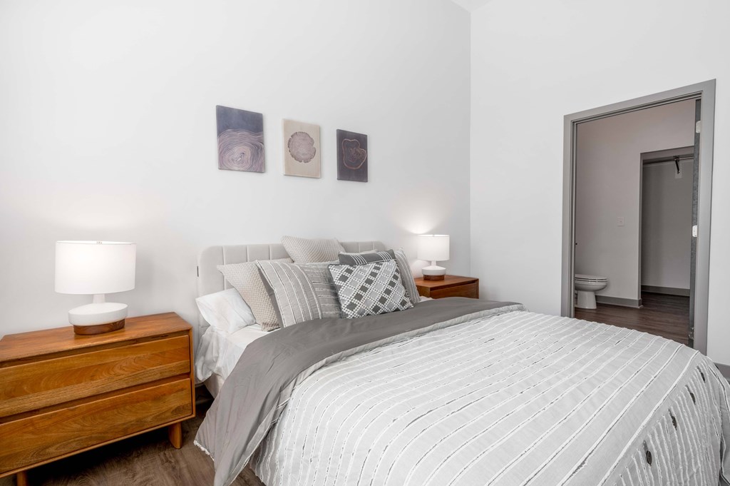 A bedroom with a large bed and two lamps on side tables.