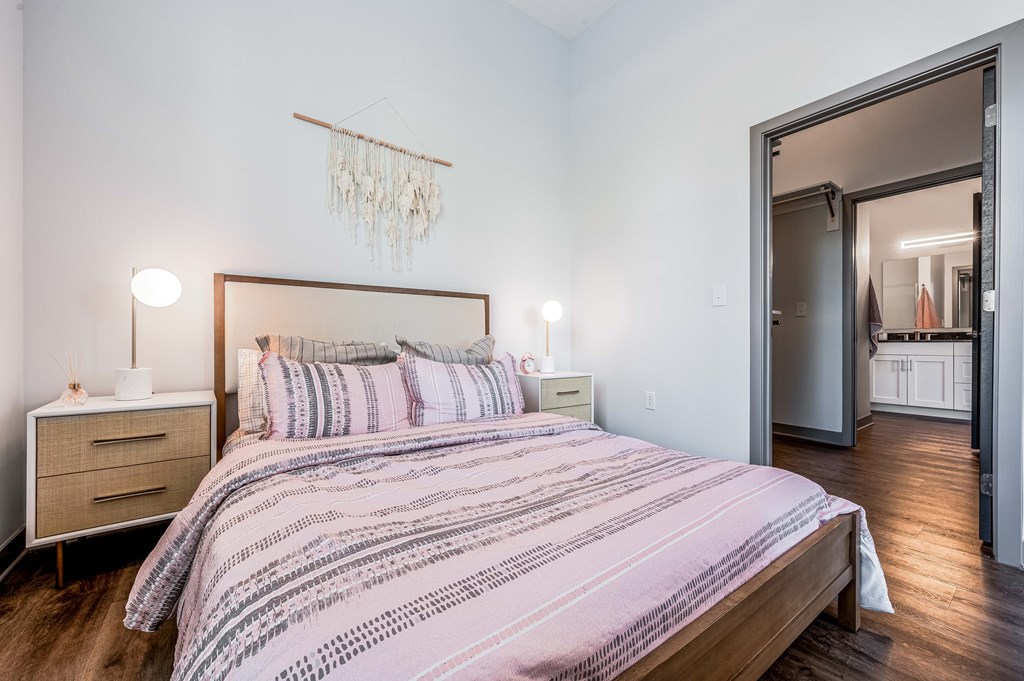 A bedroom with a bed, nightstand, and a chandelier.