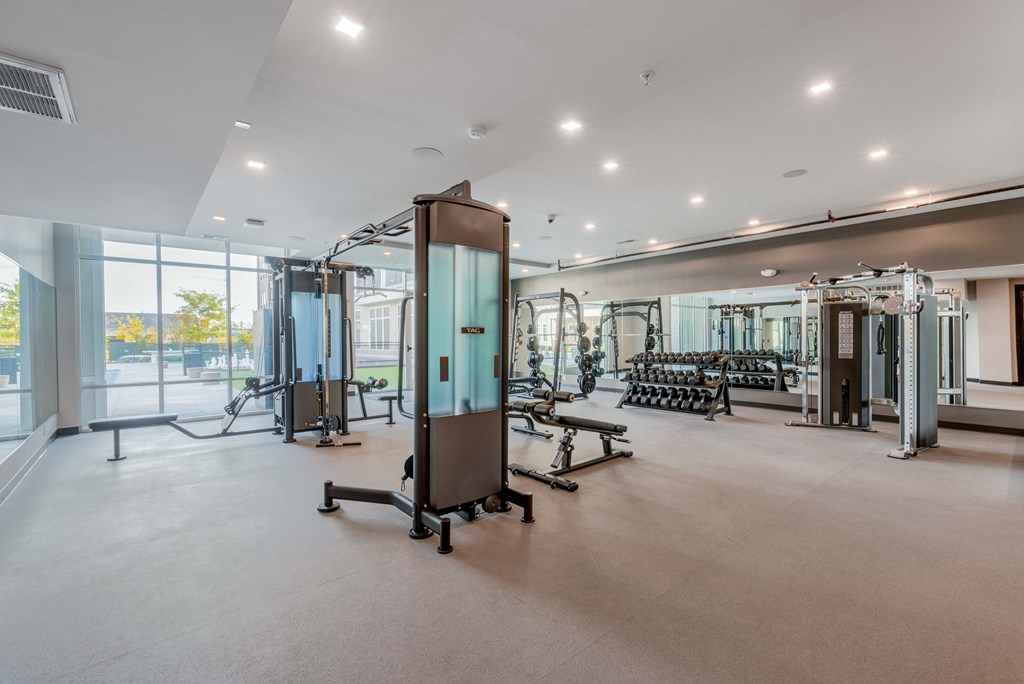 A gym with a variety of equipment including treadmills, weights, and exercise machines.