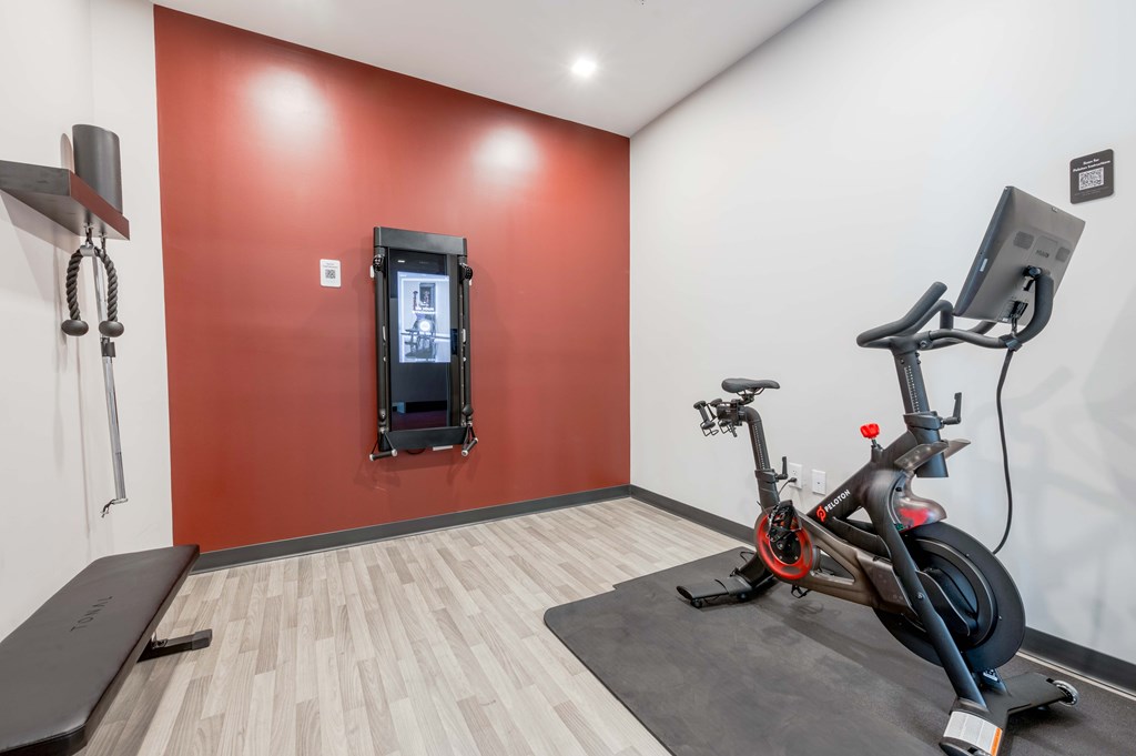 A room with a red wall and a treadmill.