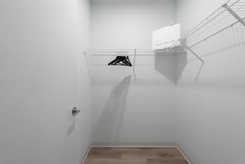 a walk in closet with a white wall and a shoe rack on the wall at The Edwin on Grand Apartments, St Louis, MO, 63103