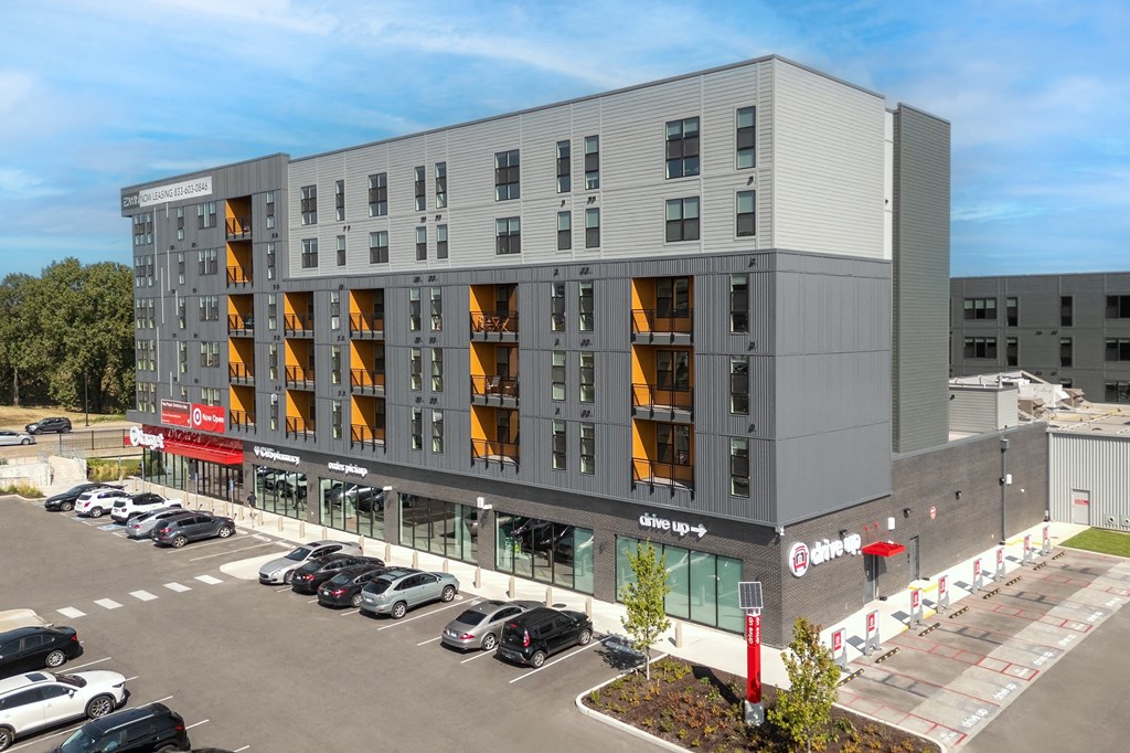 a large apartment building with cars parked in front of it at The Edwin on Grand Apartments, Missouri