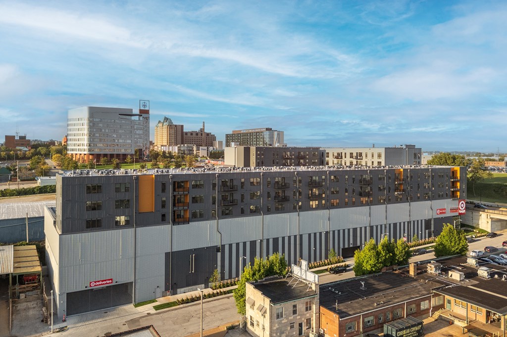 an aerial view of a large building with many windows and a city in the background at The Edwin on Grand Apartments, St Louis, MO