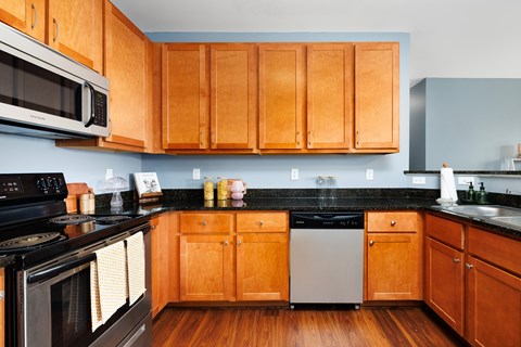 A kitchen with wooden cabinets and black appliances.