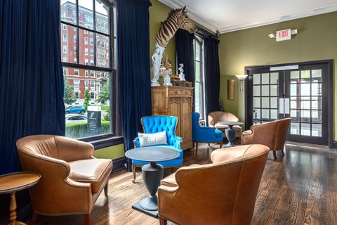 A living room with a blue sofa and brown chairs.