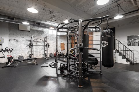 A gym with a punching bag and weights.