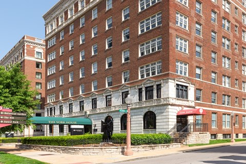 A large red brick building with a green awning in front.