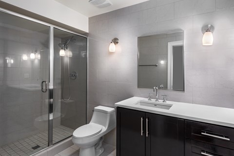 York House design bathroom with quartz countertops, oversized custom shower with glass doors and floor-to-ceiling tile.