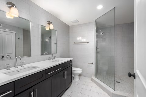 York House design bathroom with quartz countertops, oversized custom shower with glass doors and floor-to-ceiling tile.