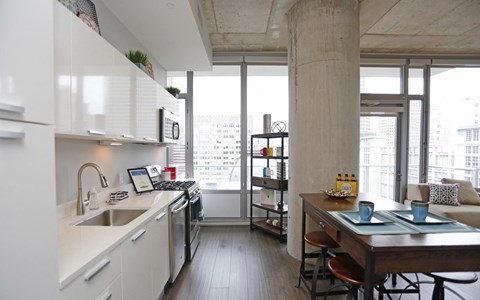 A kitchen with white cabinets and a wooden table.