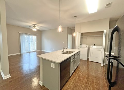 A kitchen with a white countertop and wooden floors.
