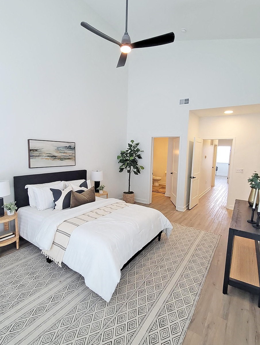 a bedroom with a bed and a ceiling fan