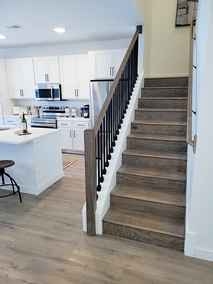 a view of the stairs from the living room into the kitchen