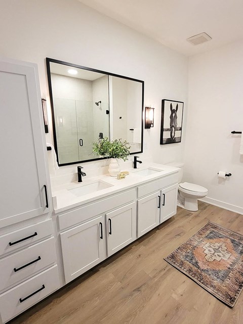 a bathroom with white walls and a wooden floor