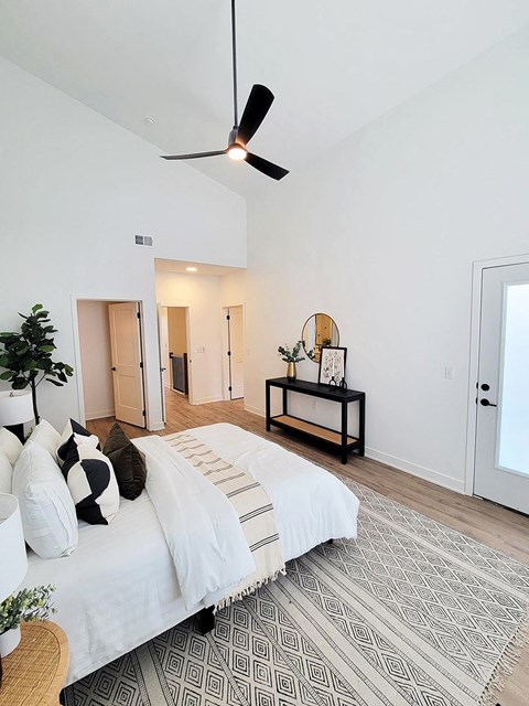 a bedroom with a bed and a ceiling fan
