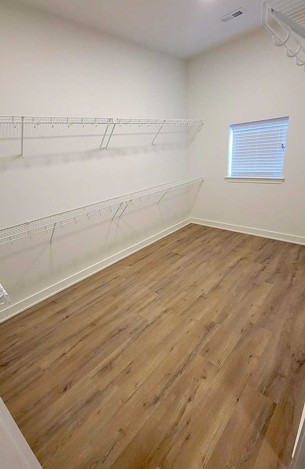 a bedroom with hardwood floors and white walls