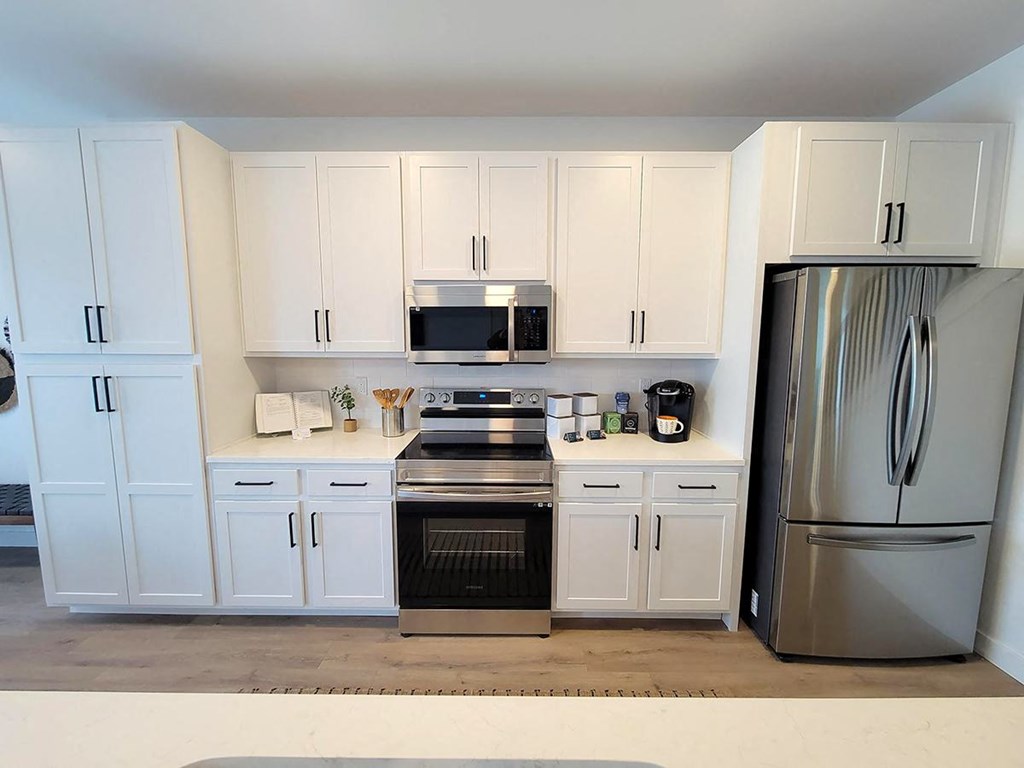 a kitchen with white cabinets and stainless steel appliances