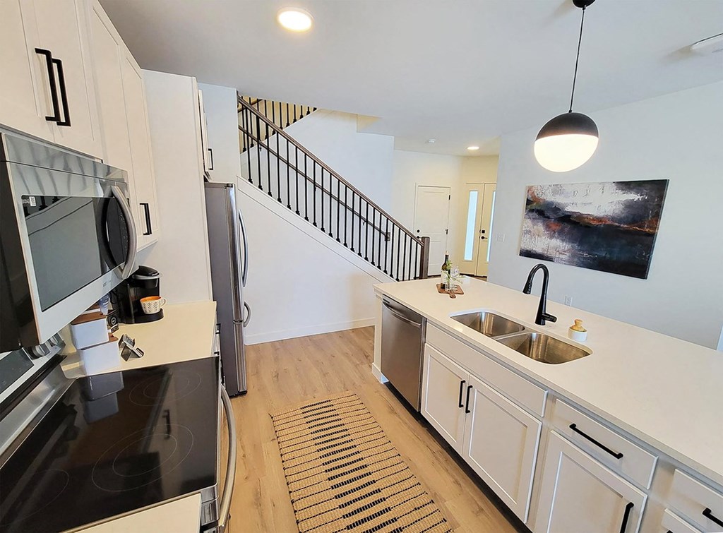 a kitchen with white cabinets and stainless steel appliances