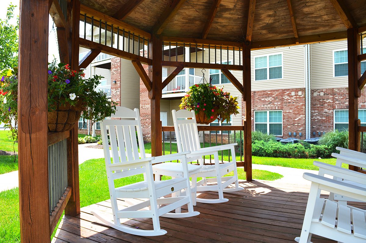 two white rocking chairs under a gazebo at Villas At Crystal Lake, Swansea