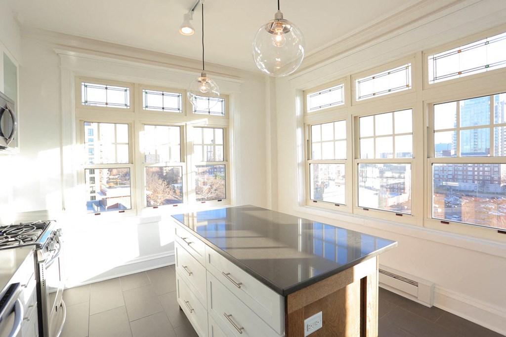 Kitchen with slate tile flooring, island, pendant lights and large corner windows. at York House, Saint Louis, MO, 63108