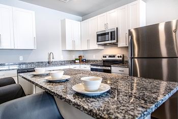 A kitchen with granite countertops and stainless steel appliances.