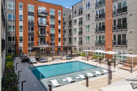 Courtyard pool with lounge chairs and seating areas at Bemiston Place Apartments, Clayton, Missouri