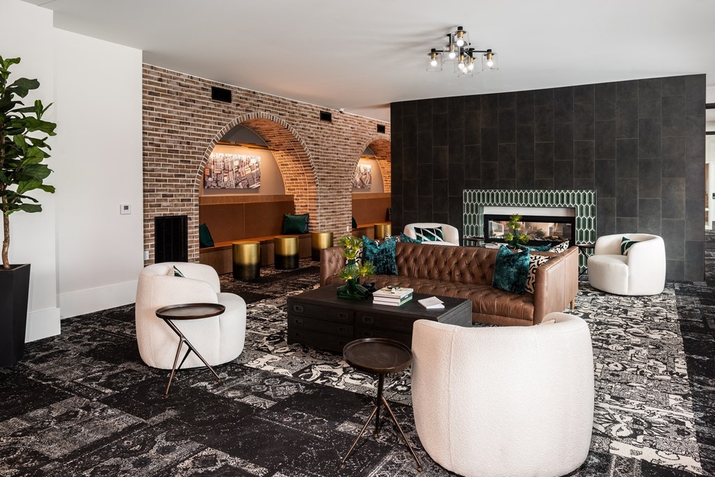 Modern resident lounge with exposed brick, rich design and conversational seating  at Chapter at the Streets of St Charles, Missouri