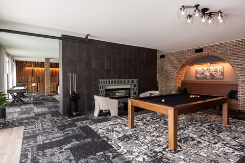 Modern resident clubroom with pool table and pass through fireplace  at Chapter at the Streets of St Charles, Saint Charles