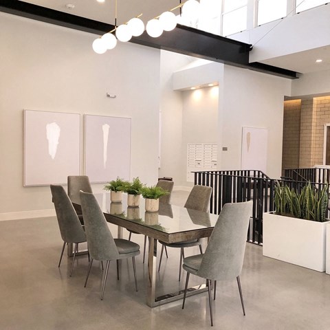 Elegant dining room with glass table and upholstered chairs at The Georgian Apartments, St Louis, Missouri