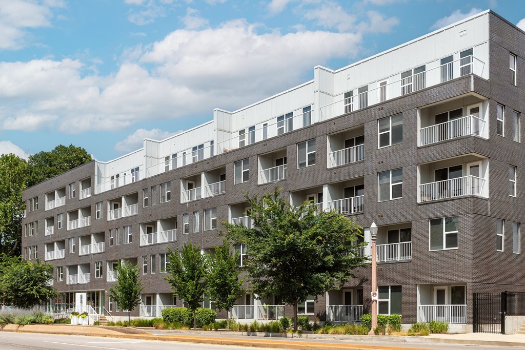 a brick and white apartment building on the side of a street at Grand Flats, Missouri