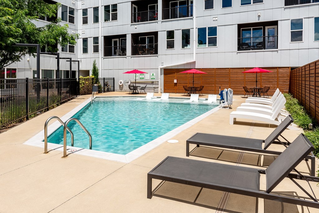 a swimming pool with lounge chairs and a building in the background at Grand Flats, St. Louis, 63104