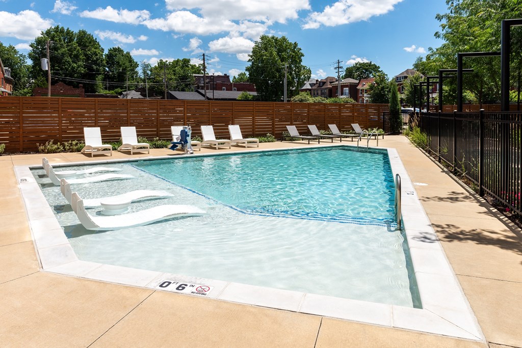 a pool with lounge chairs and a fence around it at Grand Flats, St. Louis, Missouri