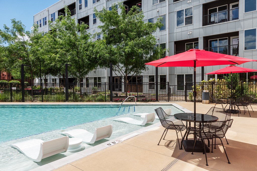 our apartments have a large pool and patio with chairs and umbrellas at Grand Flats, St. Louis, MO, 63104
