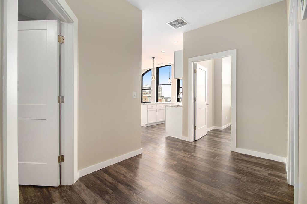 A room with a white door and a window overlooking a cityscape.