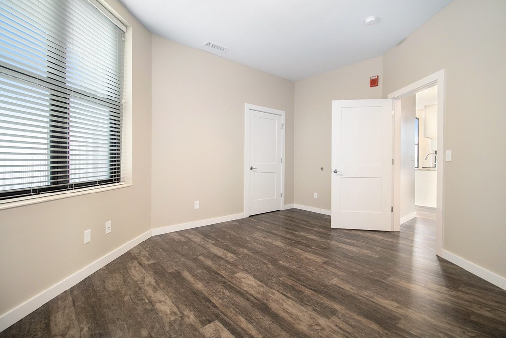 A room with wood flooring and two white doors.