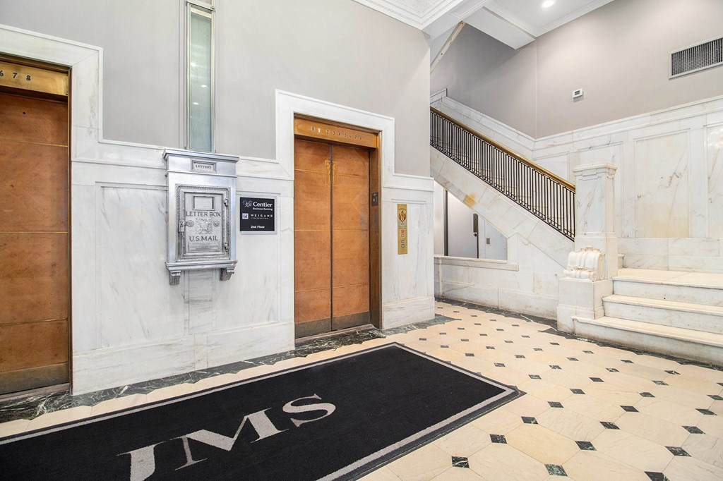 A black and white tiled floor with the letters "JMS" on it.