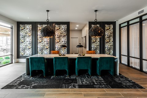 Modern resident lounge with designer lighting and large conference table  at Chapter at the Streets of St Charles, Saint Charles, 63303