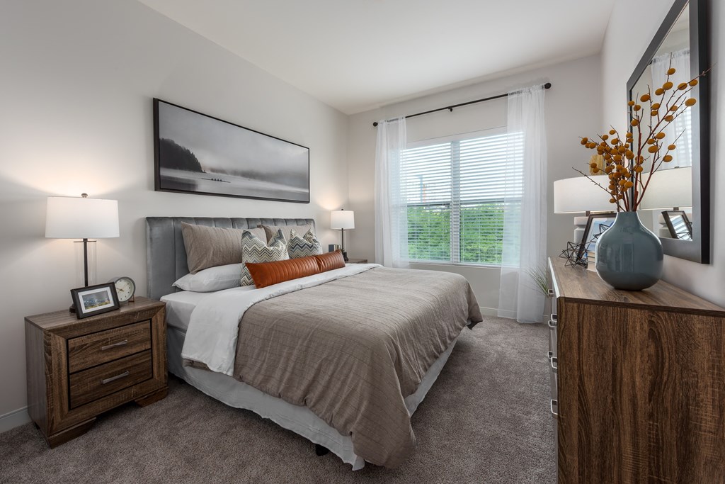 Modern bedroom with large window, dresser and nightstand  at Chapter at the Streets of St Charles, Saint Charles, 63303
