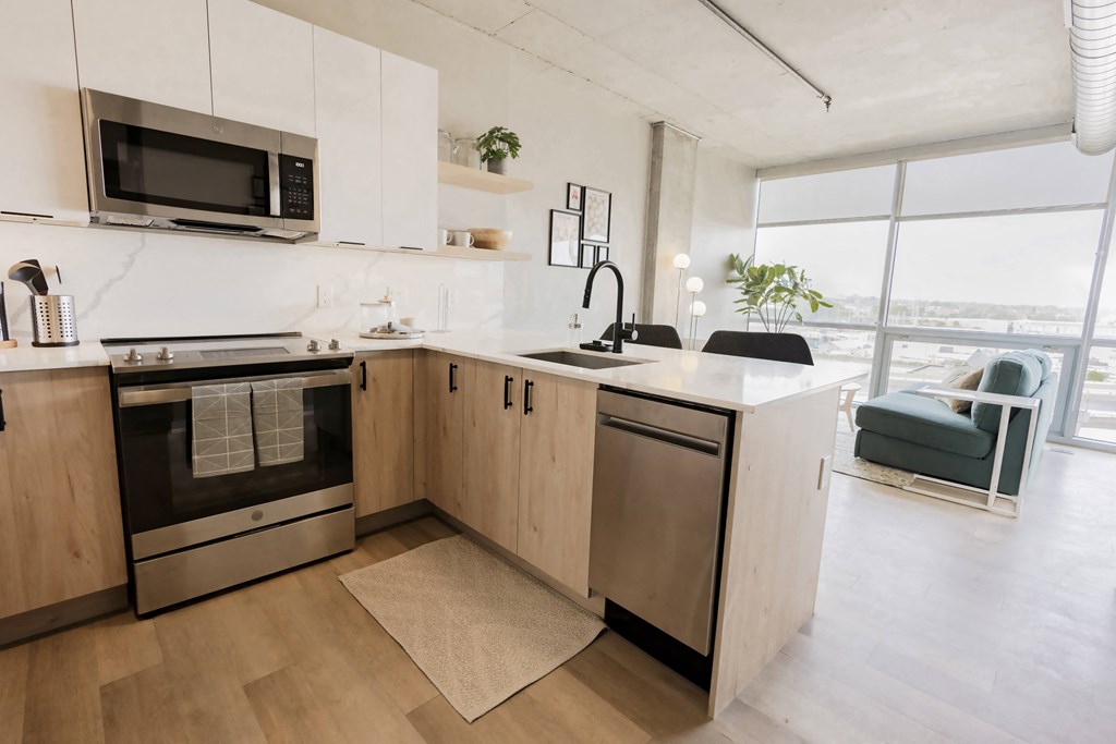 a kitchen with an island and stainless steel appliances and a window at One Foundry Way, St. Louis, 63110