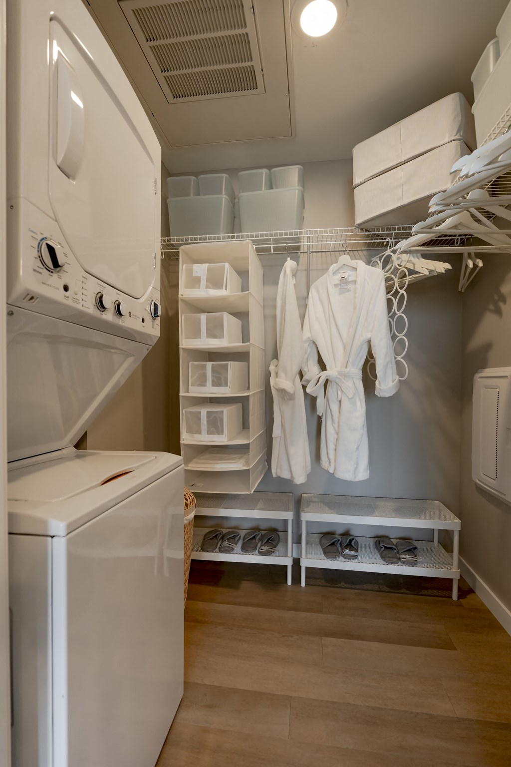 a small laundry room with a washer and dryer and a closet with robes at One Foundry Way, Missouri