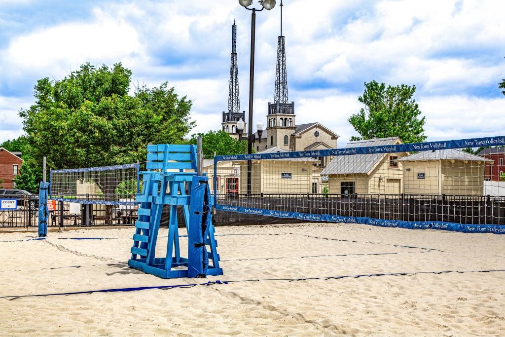 A blue lifeguard tower sits on a sandy beach.