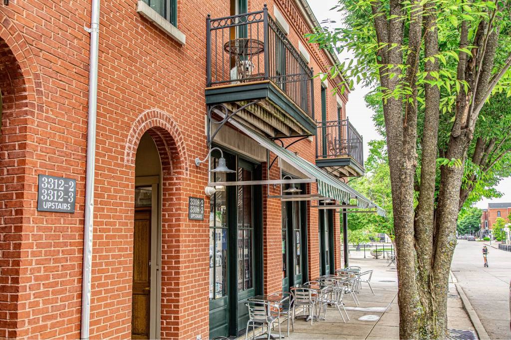 A red brick building with a balcony and a sign that says 3312-3312-3312.