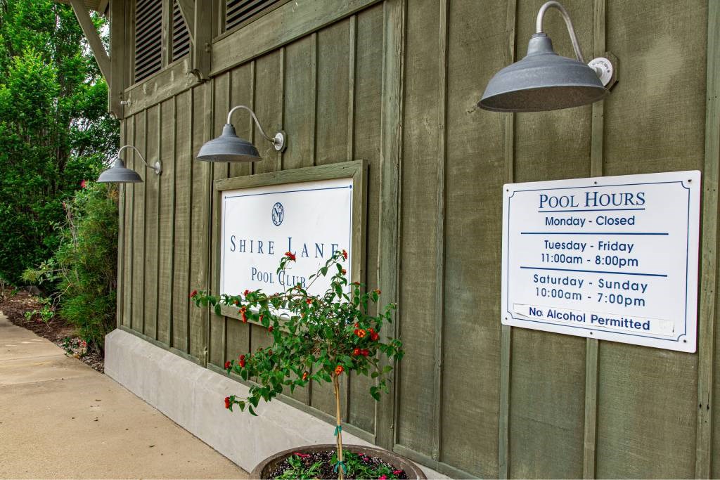 A sign on a building that says Shire Lane Pool Club.