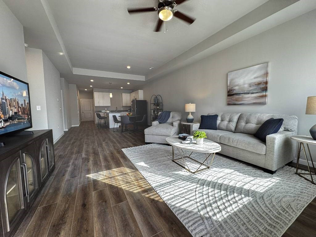 A living room with a grey couch, a coffee table, and a television.